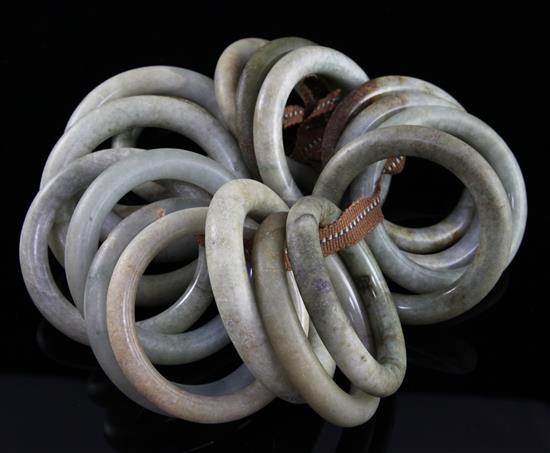 A collection of eighteen Chinese grey and green jade excavated bangles, Ming dynasty or earlier, each approx. 7.4cm diameter